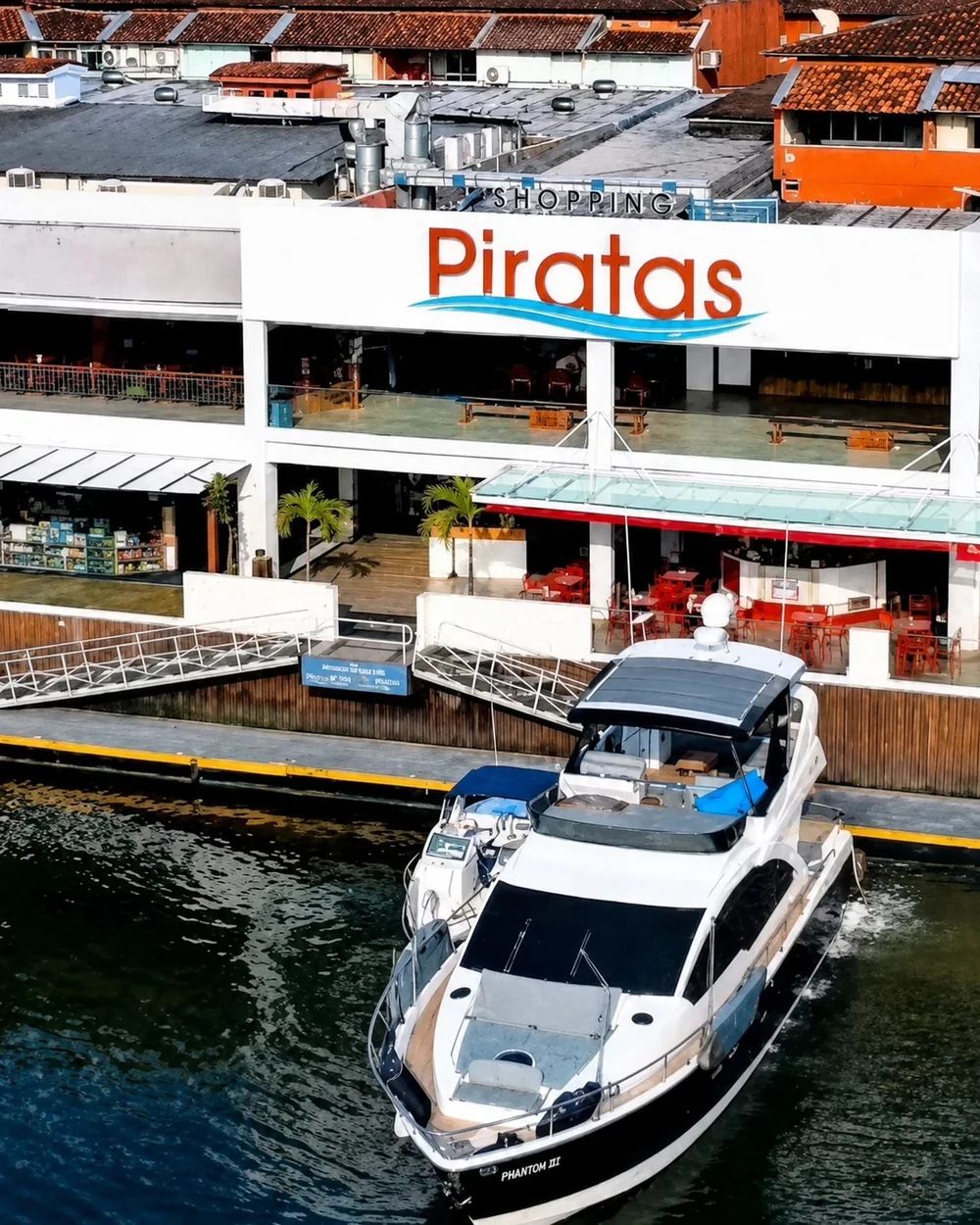 Fachada do Shopping Piratas com acesso náutico e embarcação atracada